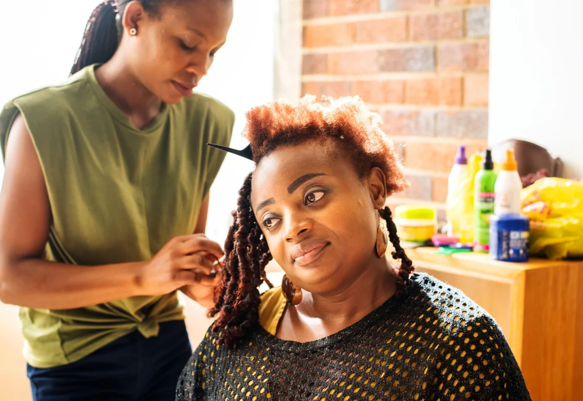 Coiffeuse tressant une cliente